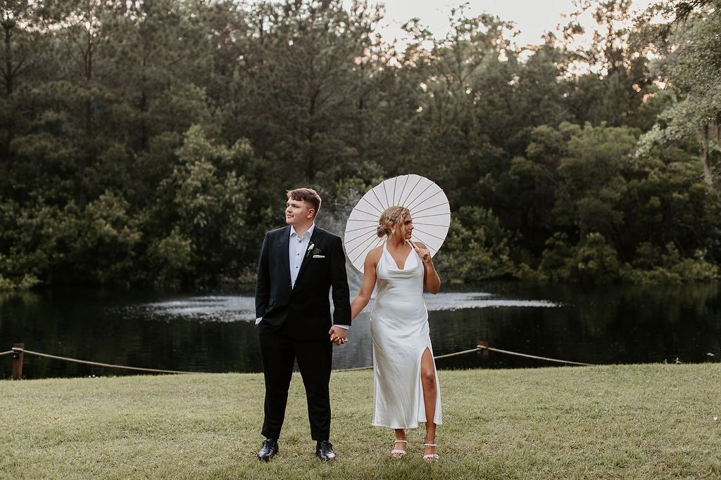 Bride and groom portrait by the water
