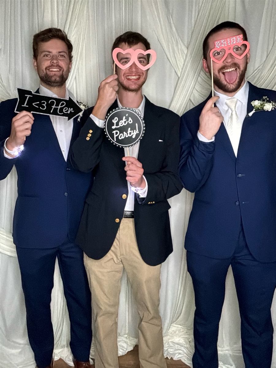 Groomsmen in masks and glasses in the photo booth